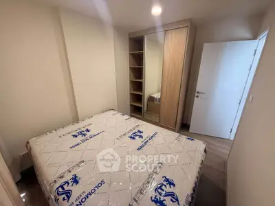 Cozy bedroom with new mattress and built-in wardrobe in modern apartment.