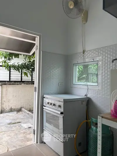 Cozy kitchen with gas stove and outdoor access, perfect for culinary enthusiasts.