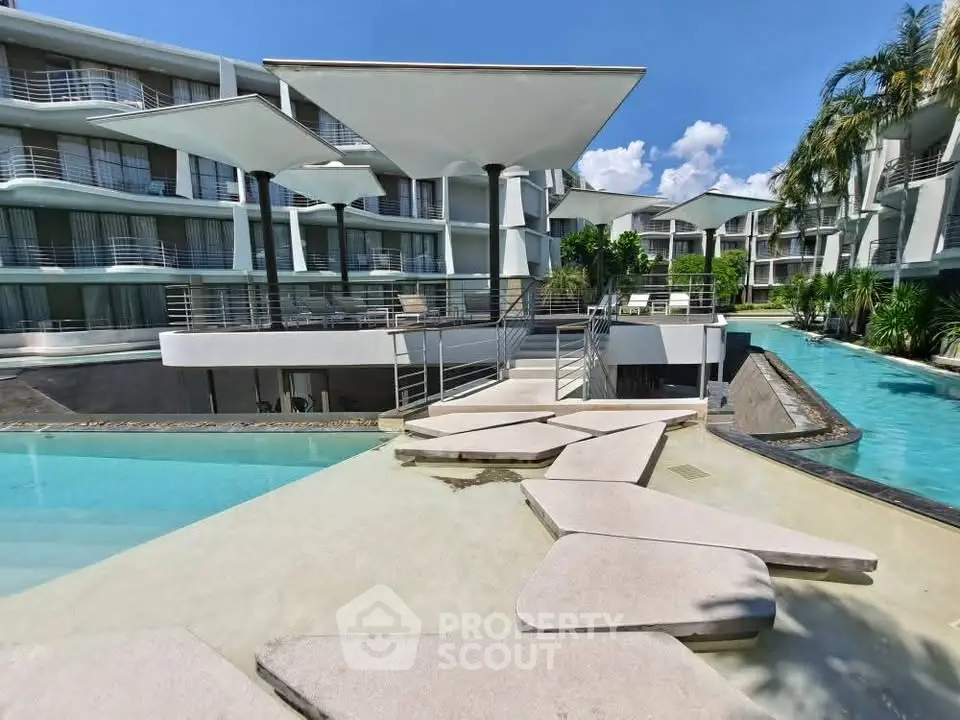 Luxurious modern apartment complex with stunning pool and unique architectural design.