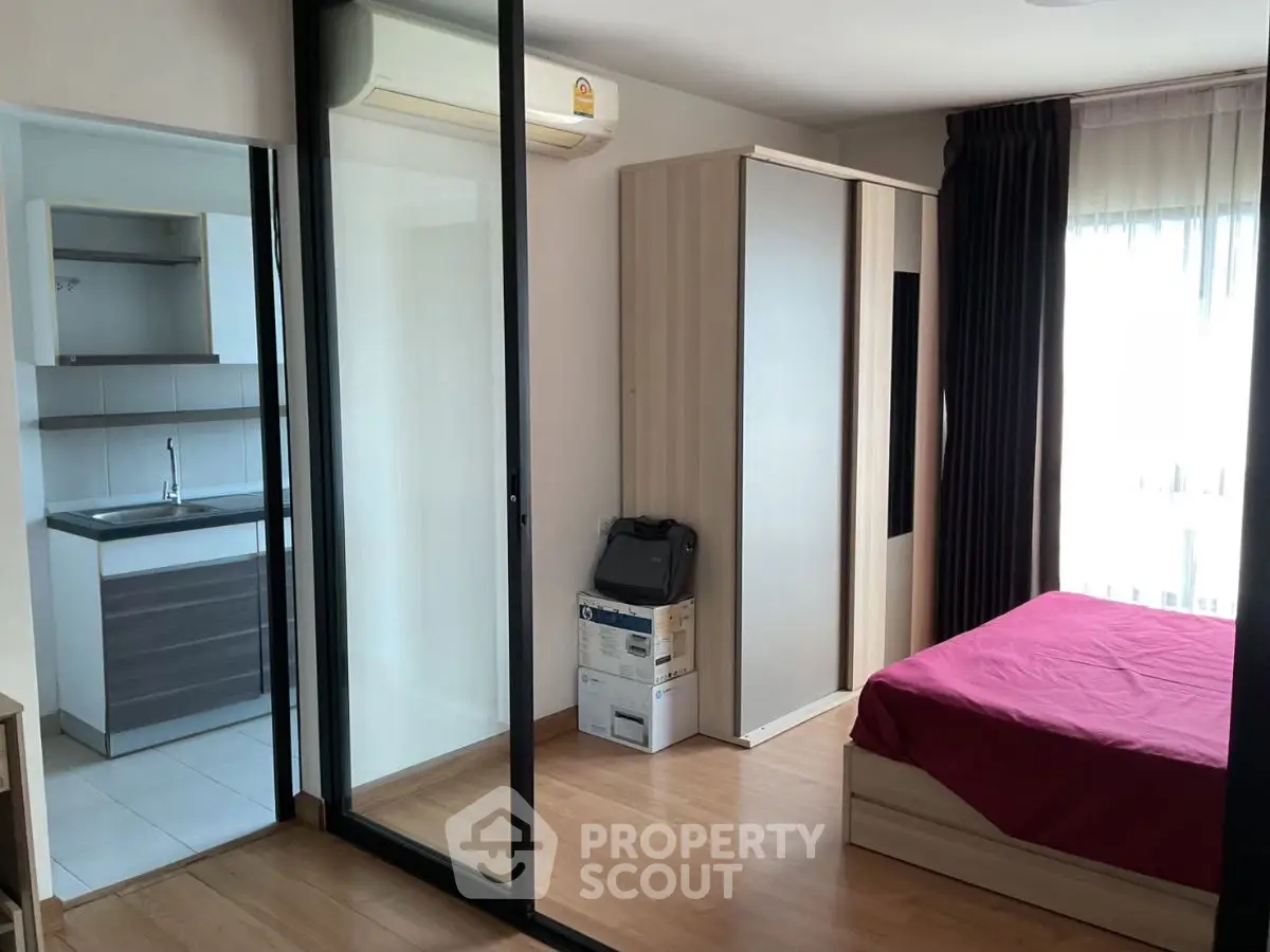 Modern bedroom with sliding glass door and compact kitchen area