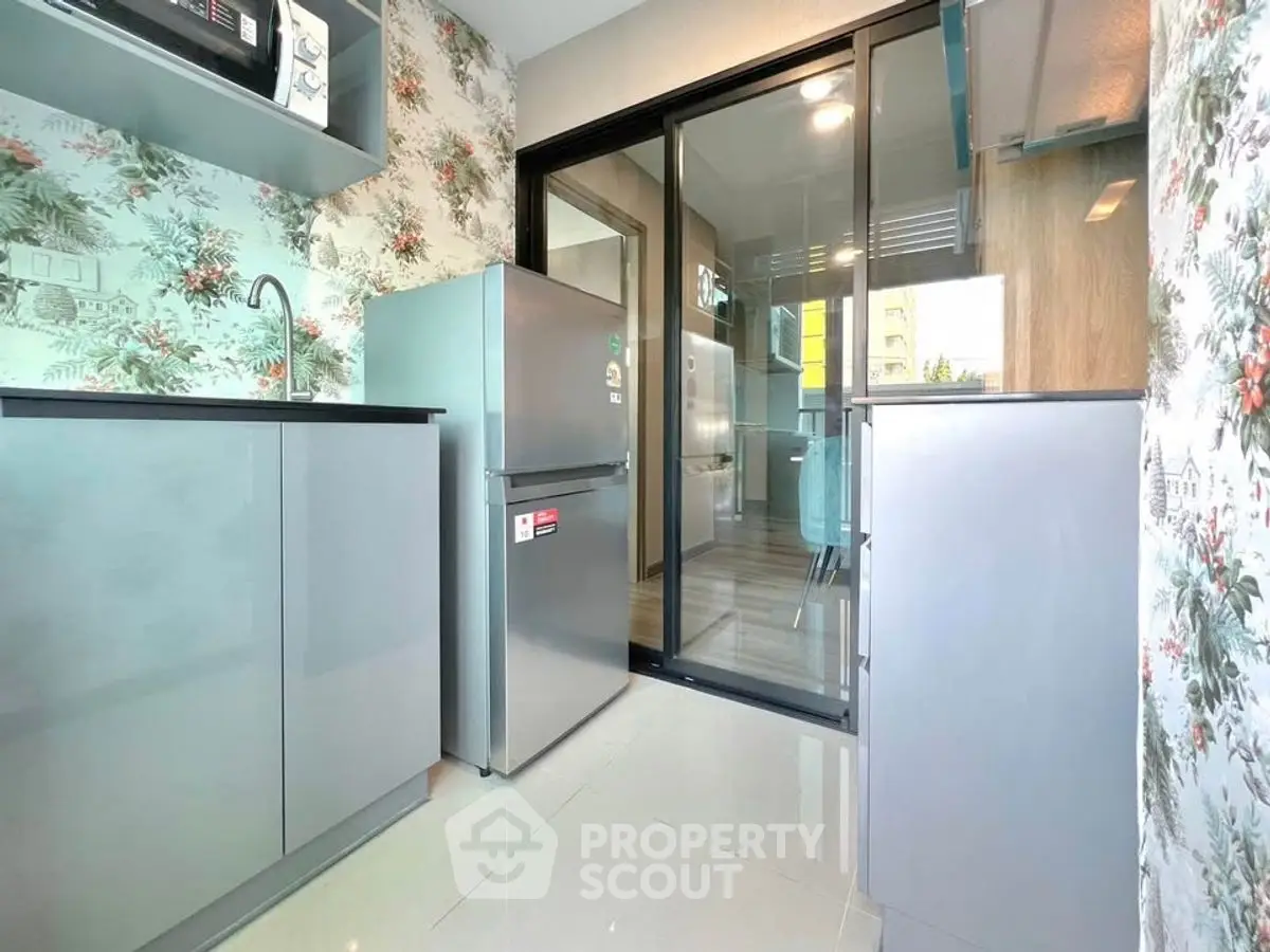 Modern kitchen with sleek cabinets and floral wallpaper design