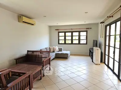 Spacious living room with large windows and modern furniture, perfect for relaxation.