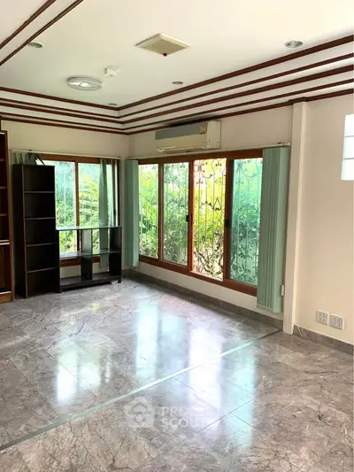 Spacious living room with large windows and marble flooring