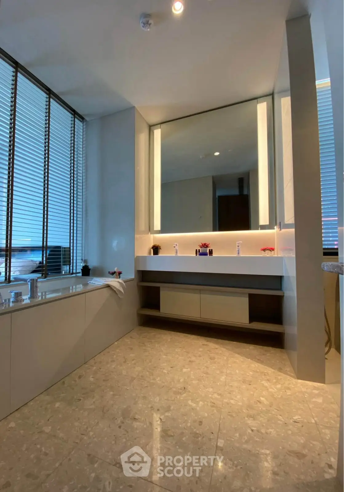 Luxurious bathroom with modern fixtures and large mirror, featuring elegant marble flooring.