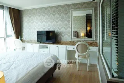 Elegant bedroom with stylish wallpaper, large mirror, and natural light from floor-to-ceiling windows.