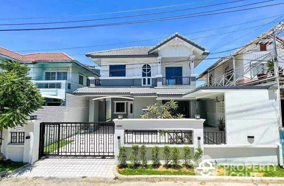 Stunning two-story modern house with gated entrance and lush greenery