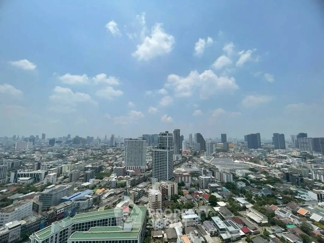 Stunning cityscape view from a high-rise building showcasing urban skyline under a clear blue sky.