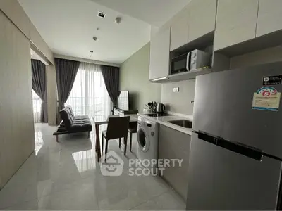 Modern open-plan kitchen and living area with sleek appliances and stylish decor.