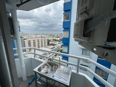 High-rise balcony with sink and cityscape view, perfect for urban living.