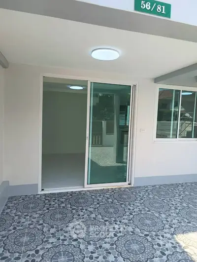 Modern exterior with sliding glass doors and patterned tile flooring, perfect for indoor-outdoor living.