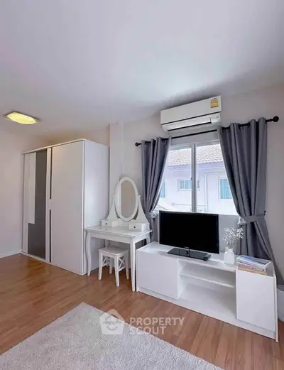 Modern bedroom with sleek furniture, air conditioning, and natural light from large window.