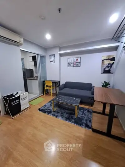 Modern living room with stylish decor and open layout, featuring cozy seating and wooden flooring.