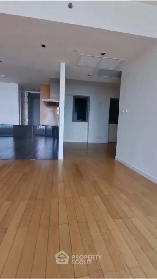 Spacious open-plan living area with wooden flooring and modern design.