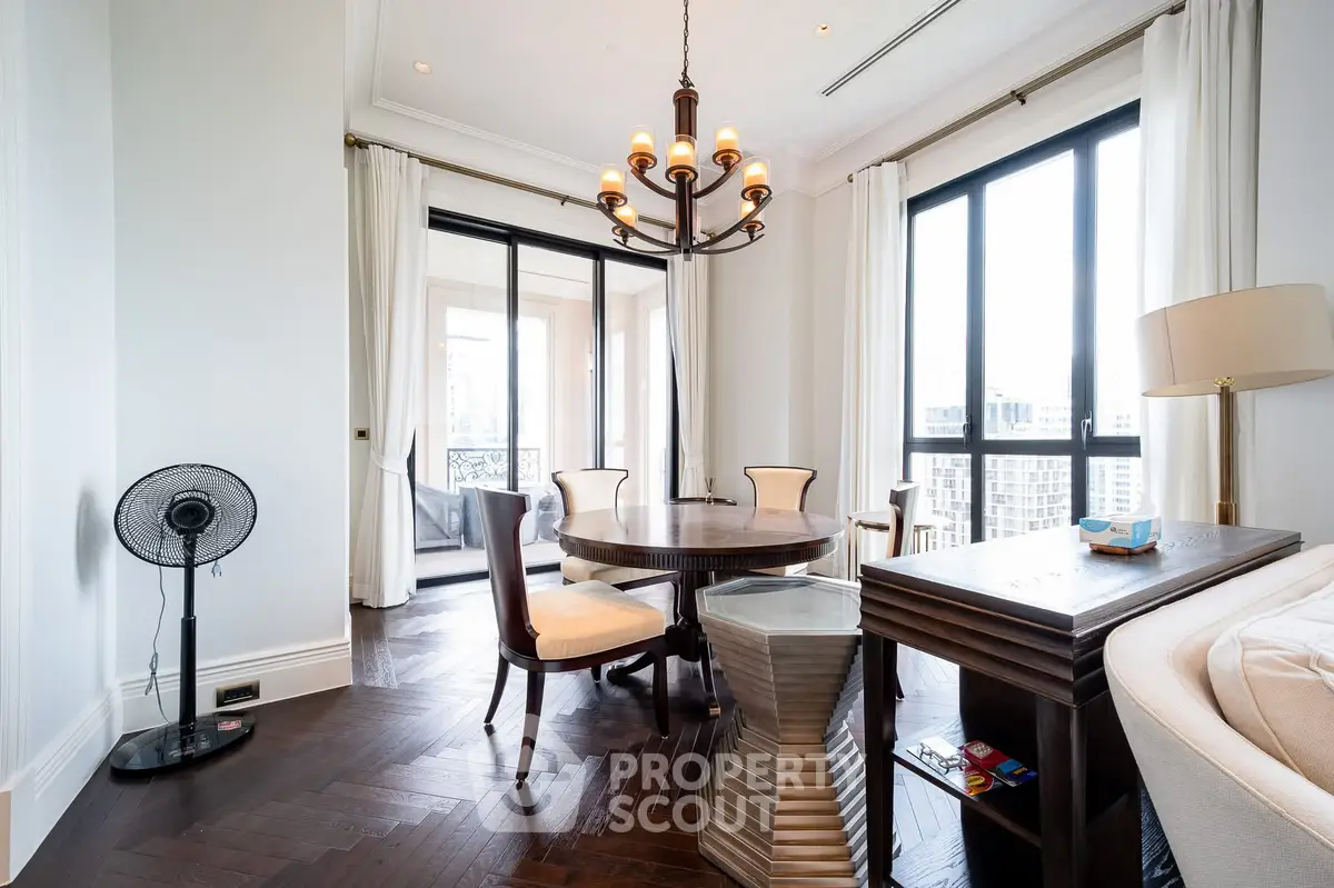 Elegant dining area with chandelier and large windows in luxury apartment
