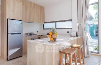 Modern kitchen with wooden cabinets and island, featuring natural light and outdoor view.