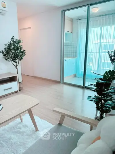 Bright and airy living room with modern decor and large sliding glass doors leading to a balcony.