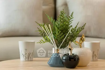 Elegant living room decor with stylish vases and greenery on a wooden coffee table.