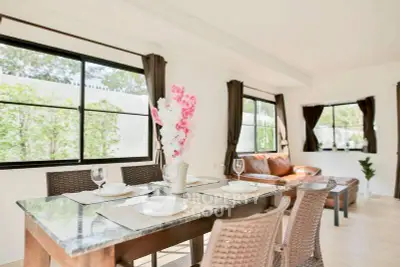 Spacious and bright living room with elegant dining area and large windows.