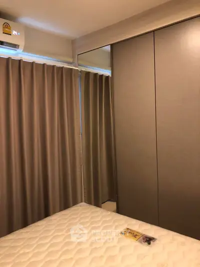 Cozy bedroom with mirrored wardrobe and air conditioning in modern apartment.