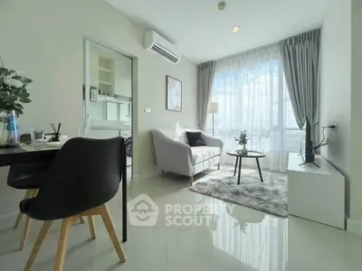 Modern living room with sleek furniture and large window offering natural light.