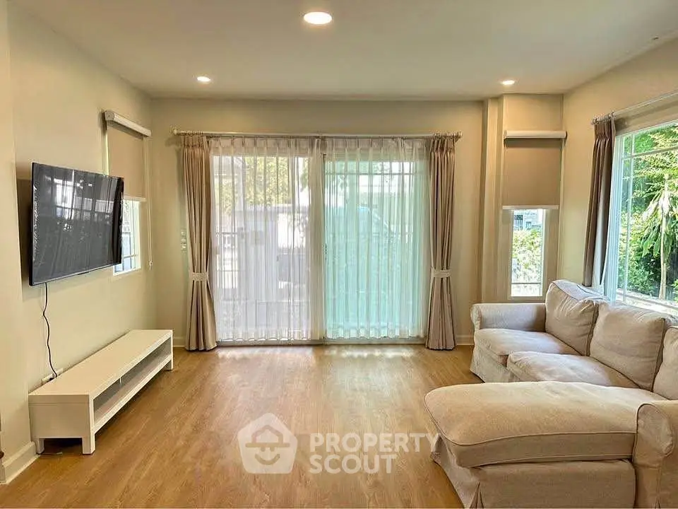 Spacious living room with large windows and cozy sectional sofa, perfect for relaxation and entertainment.