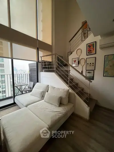 Modern duplex living room with high ceilings and stylish staircase