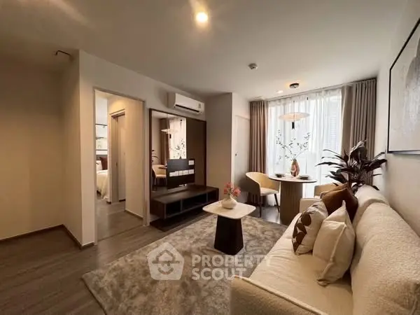 Modern living room with cozy seating and elegant dining area, featuring stylish decor and natural light.