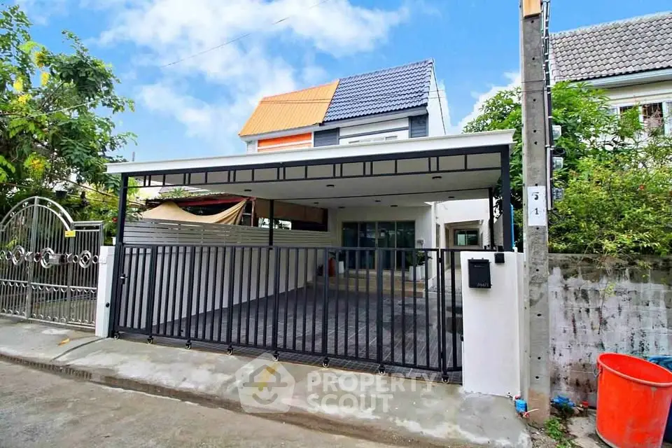Charming modern house with spacious driveway and stylish gate in a serene neighborhood.