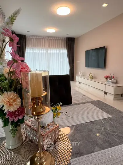 Elegant living room with modern decor, large TV, and stylish furniture, perfect for relaxation and entertainment.