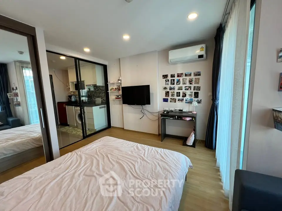 Modern bedroom with sleek design, featuring a wall-mounted TV, air conditioning, and a cozy bed.