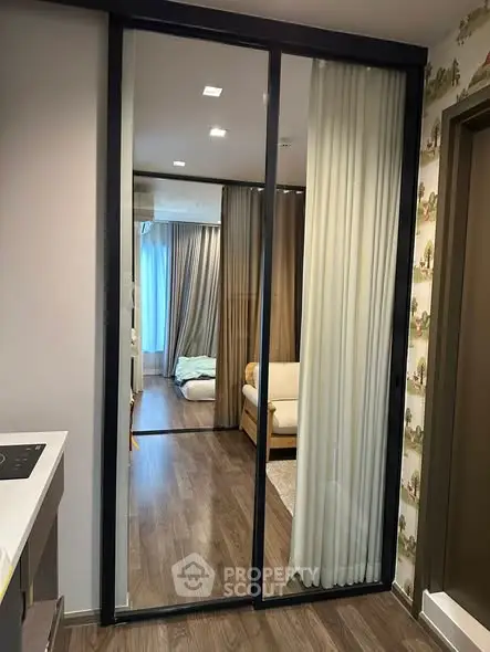 Modern apartment interior with sliding mirror doors and cozy living area.