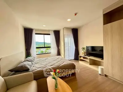 Spacious bedroom with modern decor and scenic window view, perfect for relaxation.