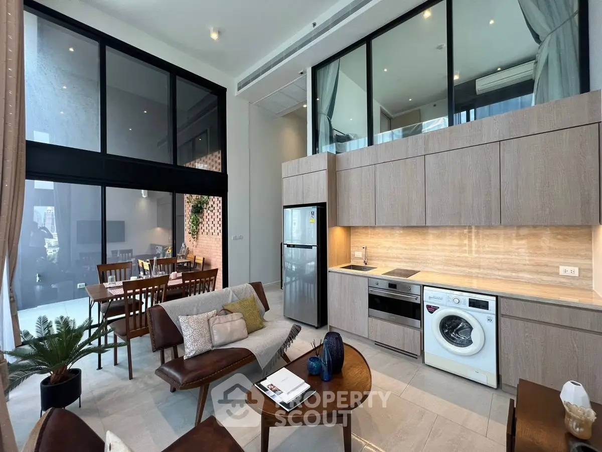 Modern open-plan living room with high ceilings and stylish kitchen appliances