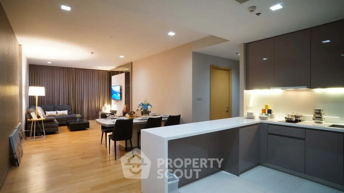 Modern open-layout living room and kitchen with sleek design and cozy ambiance.