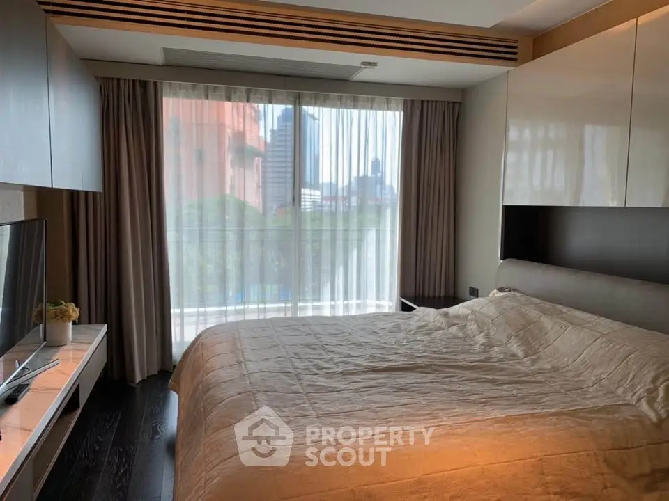 Modern bedroom with large window and city view, featuring sleek furniture and cozy bedding.