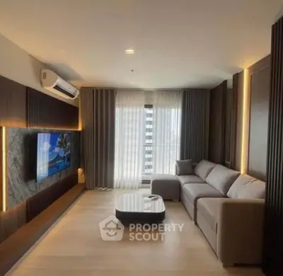 Modern living room with sleek design, large sofa, and wall-mounted TV in a stylish apartment.