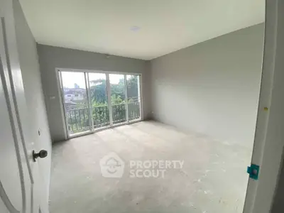 Spacious empty room with large windows and balcony view, perfect for customization.