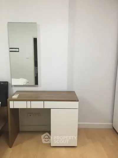 Modern minimalist study area with sleek desk and wall-mounted mirror.