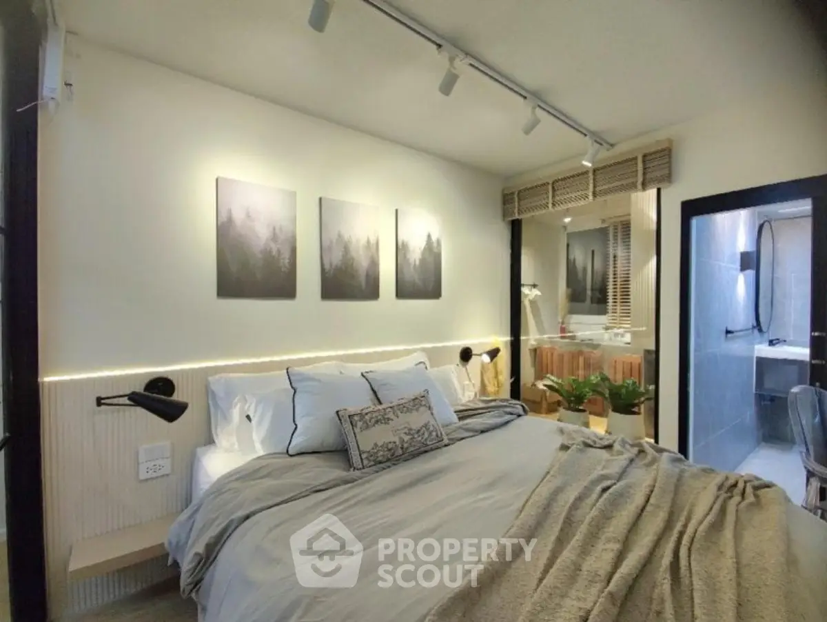 Cozy bedroom with modern decor and ensuite bathroom in stylish apartment.