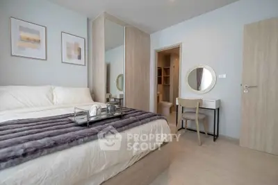 Modern bedroom with stylish decor and cozy ambiance, featuring a plush bed and elegant furnishings.
