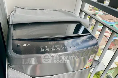 Modern washing machine on balcony with city view, perfect for urban living convenience.