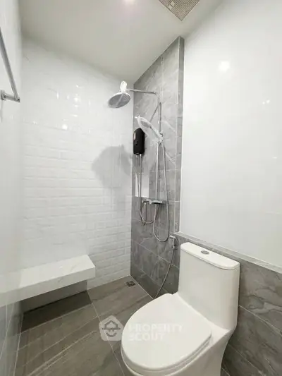 Modern bathroom with sleek shower and toilet in contemporary design.