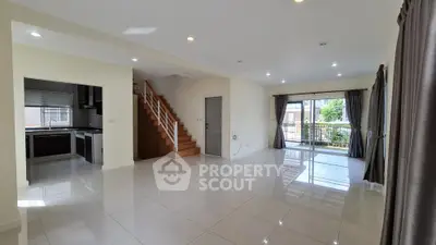 Spacious open-plan living room with modern kitchen and balcony access