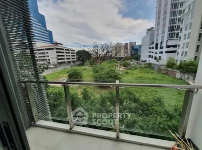 Modern balcony with lush green view in urban setting, perfect for relaxation and city living.