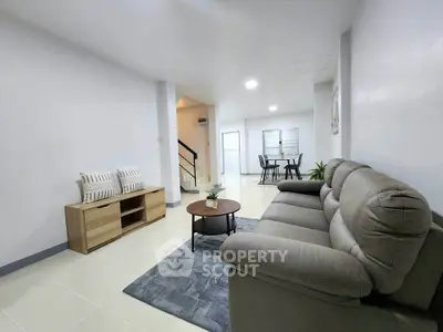 Spacious modern living room with cozy sofa and dining area in open layout