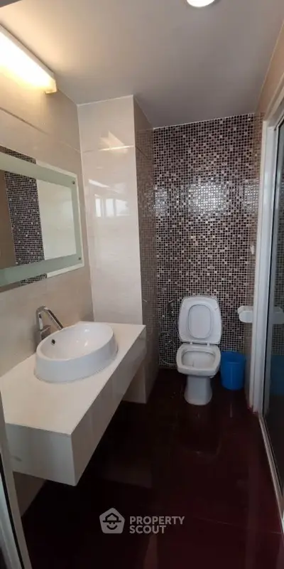 Modern bathroom with stylish mosaic tiles and sleek fixtures in a contemporary apartment.