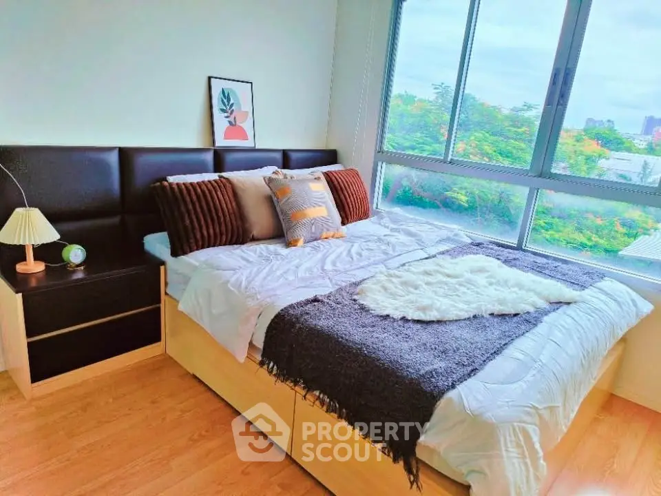 Bright and cozy bedroom with large window and stylish decor in modern apartment.
