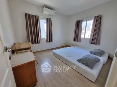 Spacious minimalist bedroom with natural light and modern furnishings