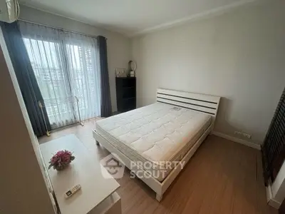 Spacious bedroom with large window and modern furnishings, perfect for comfort and relaxation.