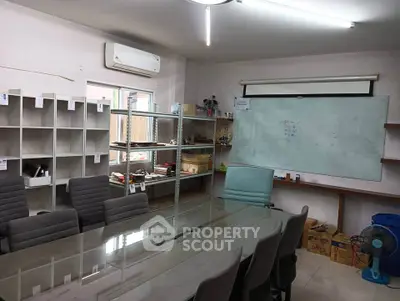 Spacious office meeting room with glass table and whiteboard, ideal for collaborative work.